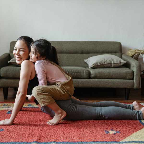 Alt Tag: picture of a woman working out on her living room together with her daughter